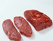 Three pieces of raw meat on white background