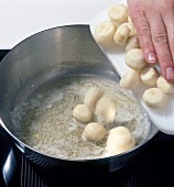 Adding chestnuts to foam of butter in saucepan, step 2