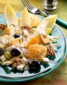 Chicorée-Käse-Salat mit Mandarinen und Weintrauben auf Teller