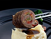 Close-up of beef with mashed potatoes and beef roulade on plate