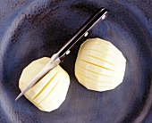 Close-up of two apples cut with knife, overhead view