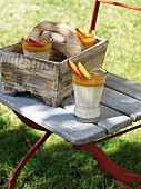 Glass of nectarine and coconut rice on wooden chair