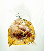 Close-up of chicken marinade in freezer bag on white background