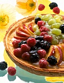 Close-up of cheesecake with fruits on top and scattered down