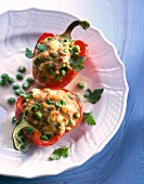 Red peppers with meat stuffing and peas on dish