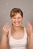 Frau mit blonden Haaren reinigt Gesicht mit Wasser