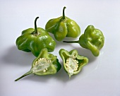 Halved and whole bell peppers on white background