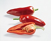 Halved and whole sweet red peppers on white background, Holland