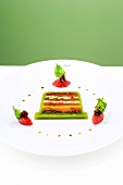 Vegetable terrine with tomato compote and olives on plate