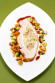 Suckling pig breast stuffed with chestnuts, sprouts and chanterelles on plate