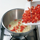 Adding diced peppers to foam mixture in saucepan, step 1