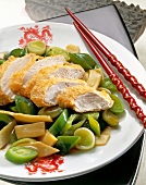 Close-up of baked chicken with leeks on plate with chopstick
