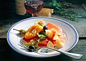 Marinated peppers with ham, olives and chillies on plate