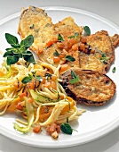 Fried eggplant cutlet with tomatoes, pasta and herbs on plate
