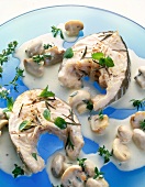 Cod cutlets with mushroom gravy garnished with marjoram and thyme herb on plate