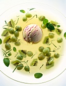 Kiwi and grapes cold soup with one scoop of ice cream in glass bowl