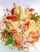 Salad with asparagus, sweet peas and tomatoes on plate