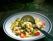 Pearl barley risotto peppers and bacon with spoon on plate