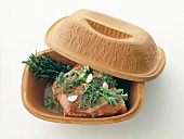 Piece of quality meat with herbs in clay pot