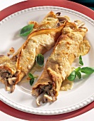 Close-up of crepes stuffed with mushrooms on plate