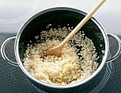 Rice with sauted and diced onion in pot
