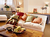 Wohnzimmer: Couch, Kissen farbenfroh Obstschalen auf Tisch, warm