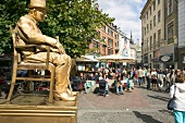 Mime artist wearing golden outfit sitting on street in Copenhagen, Denmark
