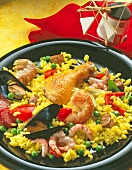 Paella mit Hähnchen, Miesmuscheln, Scampi u. Schweinegulasch auf Teller