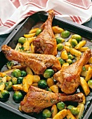 Marinated turkey drumsticks with Brussel sprouts, potatoes and herbs on serving dish
