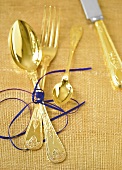 Besteck in Gold, Vorlage f. Napoleon gefertigt, mit lila Band gebunden