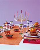 mexikanisch gedeckter Tisch in Rotund Orangetönen mit Kerzenleuchter