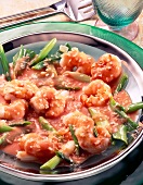 Shrimp with coconut, spring onions, tomato sauce and tabasco on plate