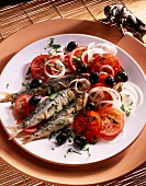 Spanischer Tomatensalat mit Sardinen und Oliven auf Teller