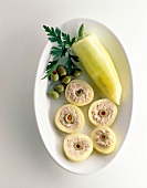 Rolls filled with mince, olives and herbs in serving dish