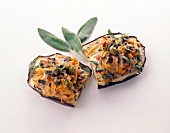 Eggplant slices with meat filling garnished with vegetables and olives on white background