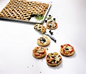 Spinach pies, mini pizzas with olives and herbs on white background