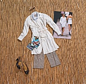 Knitted woollen floral pattern coat in white, grey trousers with postcards and pen on mat