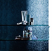Various male beauty products and cosmetics on glass shelve