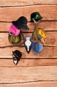 Green, yellow, pink, blue and black hats hanging on stag