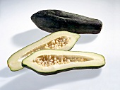 Whole and halved long green papaya vegetable on white background
