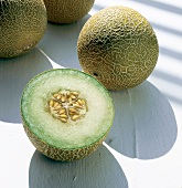 Halves of galia melon on white surface