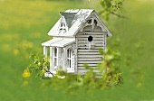 American styled white birdhouse in garden
