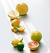 Halved and whole orange, lime, lemon and citrus on white background