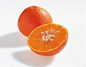 Whole and halved mandarin orange on white background