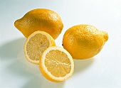 Whole and halved teardrop shaped lemons on white background