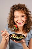 Woman holding bowl with salad in hand