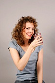 Woman drinking glass of water, smiling