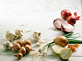 Various onions and garlic bulbs on white background