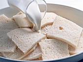 Close-up of milk being poured on bread in bowl