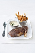 Steak with bearnaise sauce and French fries on plate